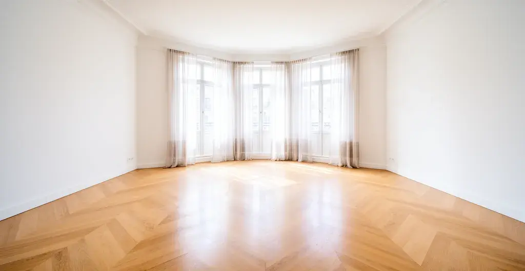 Séjour lumineux d'un appartement neuf avec grandes baies vitrées et parquet clair